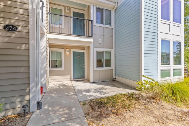 doorway to property featuring a balcony and board and batten siding