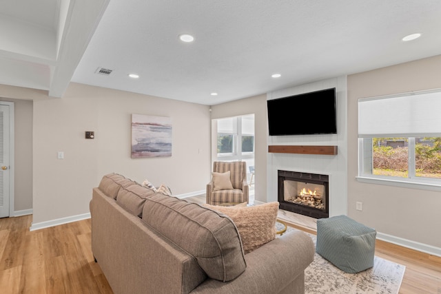 living room featuring light wood-type flooring, a wealth of natural light, and baseboards