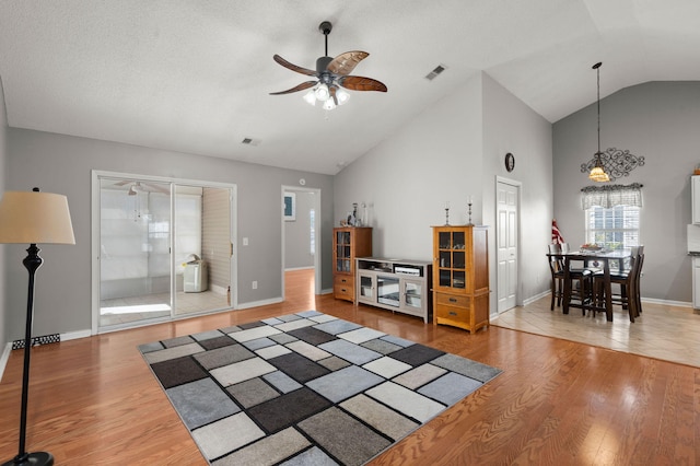 living area featuring a ceiling fan, visible vents, and wood finished floors