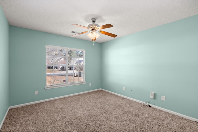 spare room with baseboards, visible vents, a ceiling fan, a textured ceiling, and carpet flooring