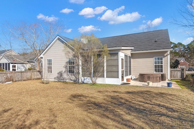 back of property with a fenced backyard, a sunroom, a yard, a patio area, and a hot tub