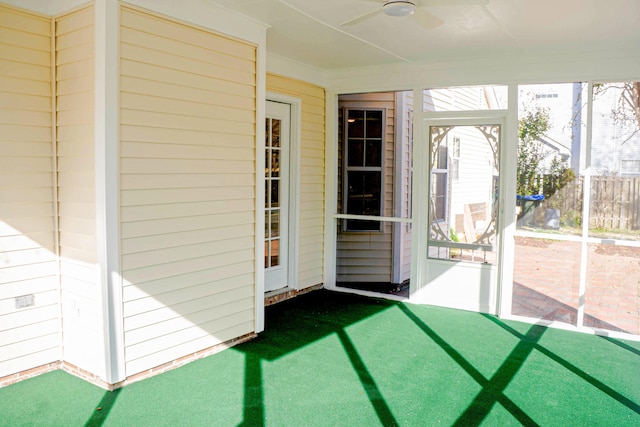 unfurnished sunroom with ceiling fan