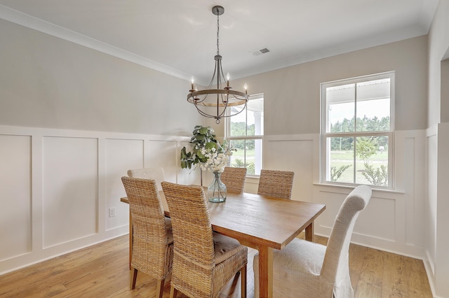 dining room with a chandelier, light hardwood / wood-style floors, and ornamental molding