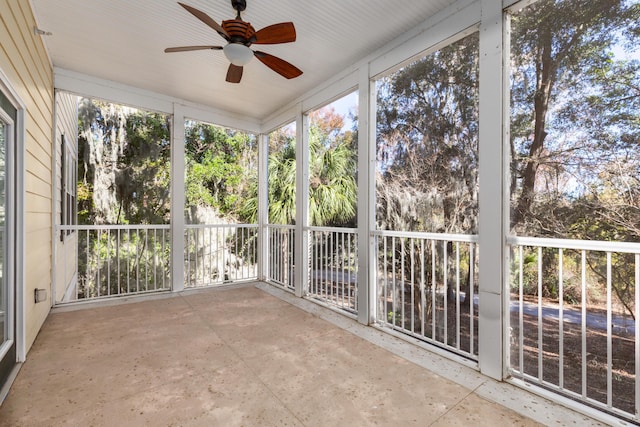 unfurnished sunroom featuring ceiling fan