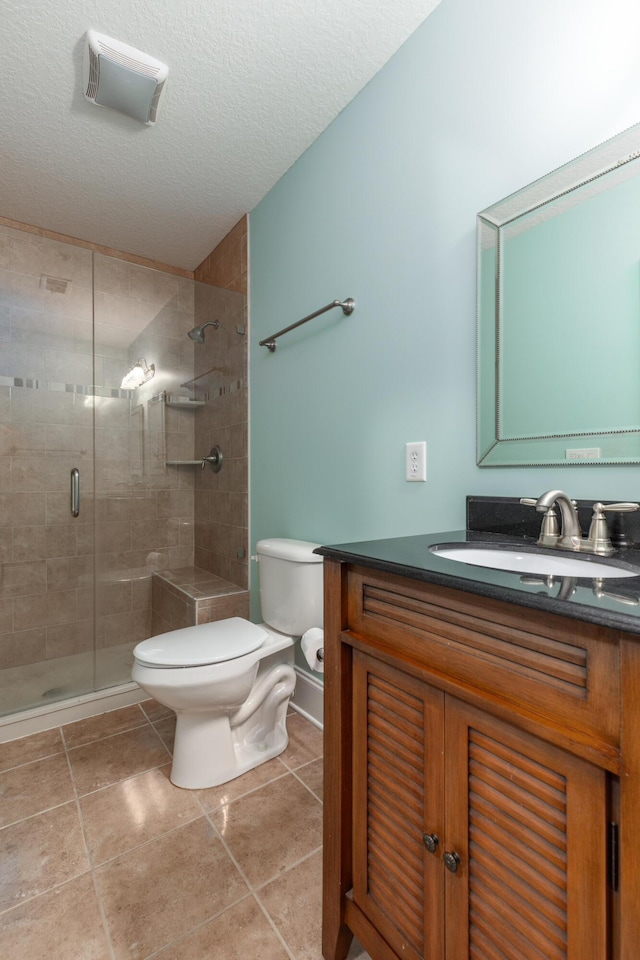 bathroom featuring vanity, a textured ceiling, toilet, and a shower with shower door