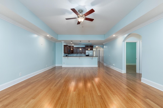 unfurnished living room featuring light hardwood / wood-style floors, ceiling fan, and ornamental molding