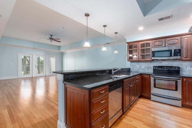 kitchen featuring kitchen peninsula, sink, light hardwood / wood-style floors, and appliances with stainless steel finishes