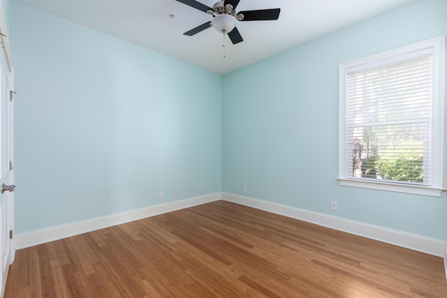 unfurnished room featuring ceiling fan, hardwood / wood-style floors, and a healthy amount of sunlight