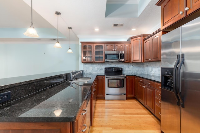 kitchen featuring stainless steel appliances, crown molding, sink, pendant lighting, and light hardwood / wood-style flooring