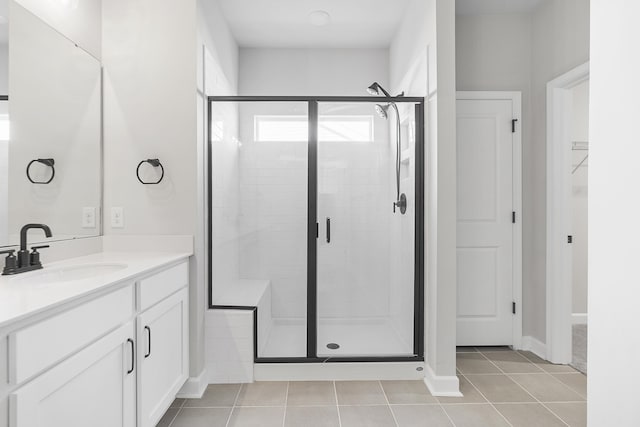 bathroom featuring tile patterned flooring, a stall shower, and vanity