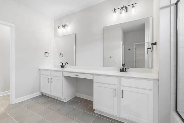 bathroom featuring a sink, baseboards, double vanity, and tile patterned flooring