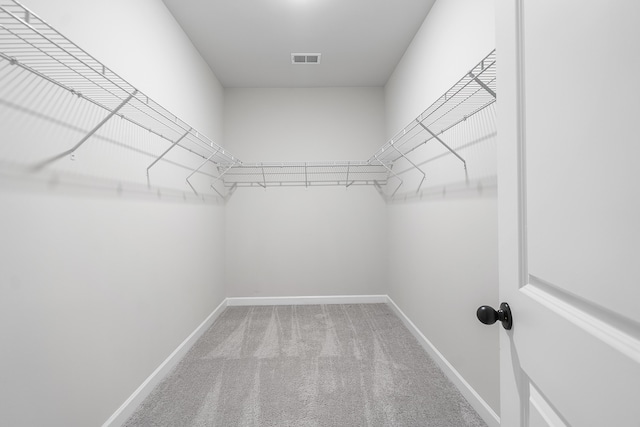 walk in closet featuring visible vents and carpet flooring