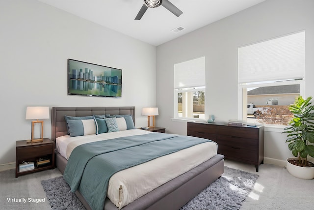 bedroom featuring visible vents, baseboards, light colored carpet, and a ceiling fan