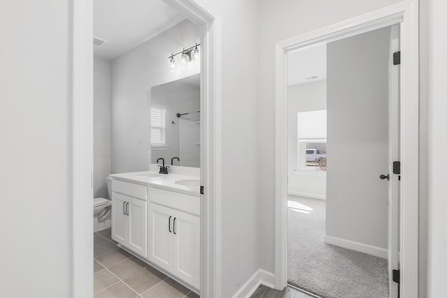 full bathroom featuring visible vents, baseboards, toilet, double vanity, and a sink