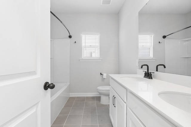 bathroom featuring tile patterned floors, toilet, bathtub / shower combination, and a sink