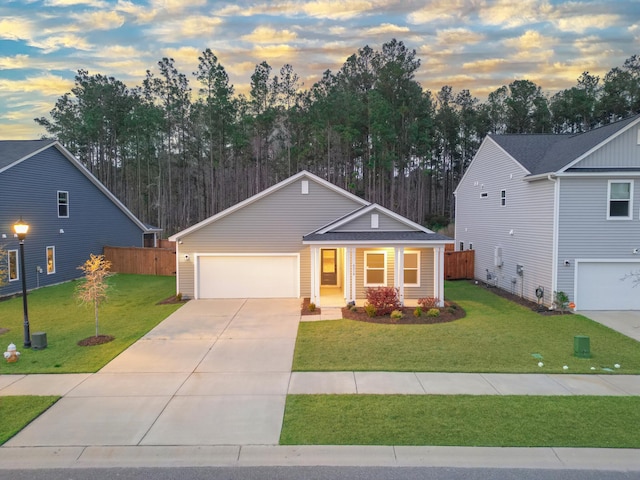 view of front of house featuring an attached garage, a yard, fence, and driveway