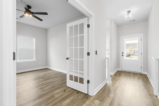 entryway featuring wood finished floors, visible vents, and baseboards