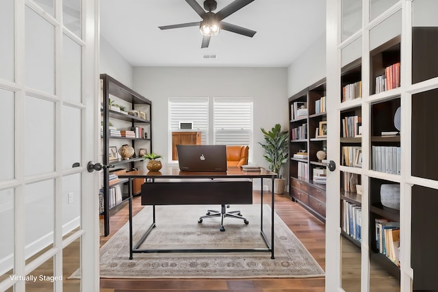 office space featuring wood finished floors, visible vents, and ceiling fan