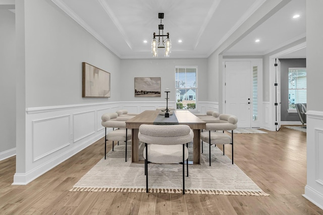 dining area with a healthy amount of sunlight, an inviting chandelier, and light hardwood / wood-style flooring