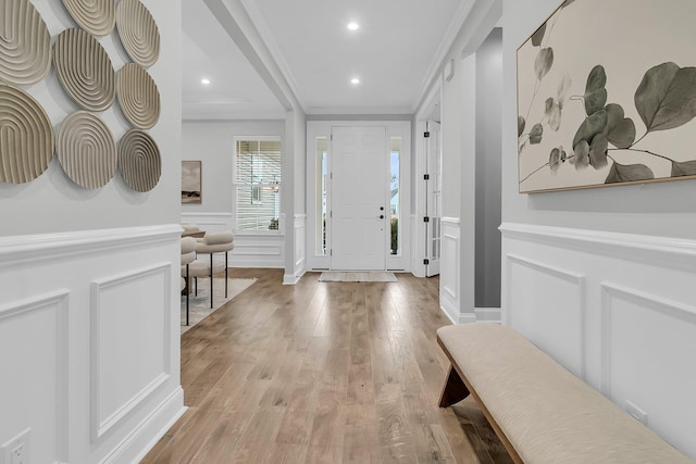 foyer entrance featuring ornamental molding and light hardwood / wood-style floors