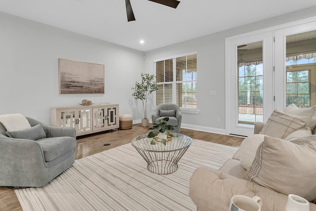 living room with ceiling fan and light hardwood / wood-style flooring