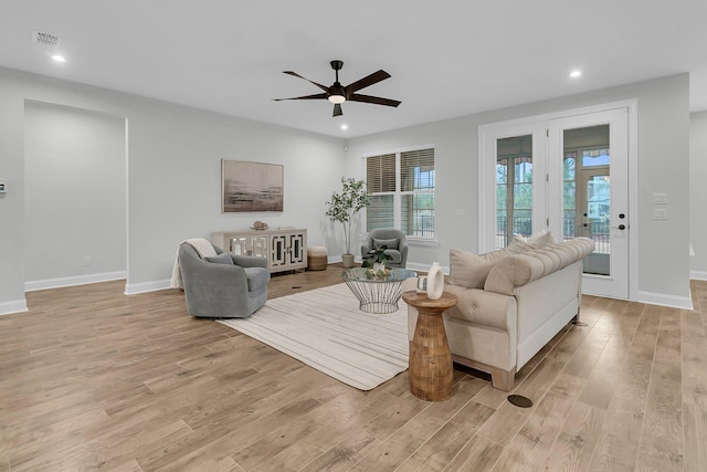 living room featuring ceiling fan and light hardwood / wood-style floors