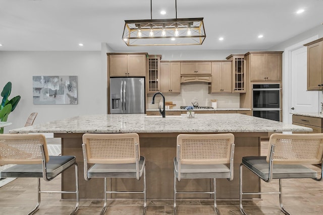 kitchen with a large island, a kitchen breakfast bar, and appliances with stainless steel finishes