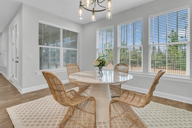 dining area featuring hardwood / wood-style floors and a notable chandelier