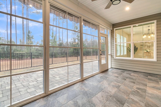 unfurnished sunroom with ceiling fan