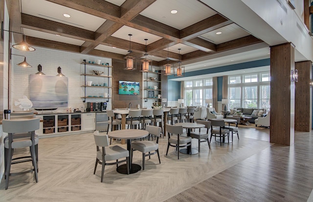 dining space with coffered ceiling, beamed ceiling, and light parquet flooring