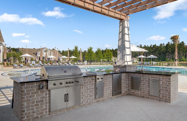 view of patio / terrace with sink, a community pool, a pergola, grilling area, and an outdoor kitchen