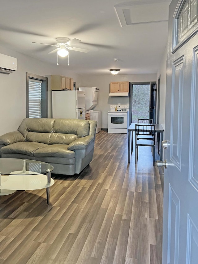 living room featuring hardwood / wood-style floors, washer / clothes dryer, an AC wall unit, and ceiling fan