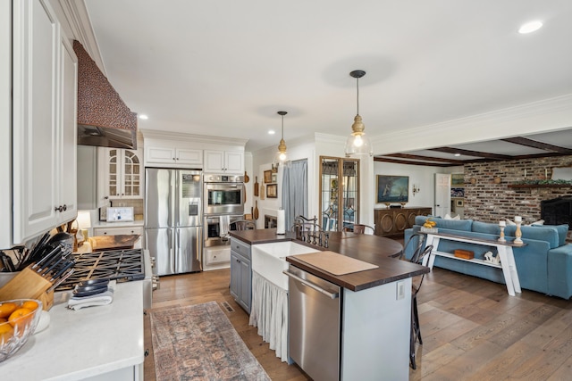 630 Cain Dr, Mount Pleasant, SC 29464 - kitchen featuring stainless steel appliances, open floor plan, a sink, white cabinetry, and an island with sink
