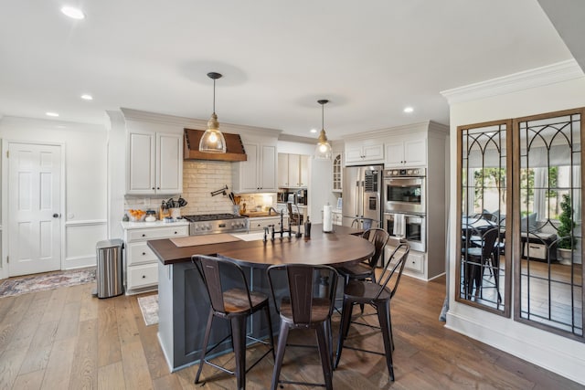 630 Cain Dr, Mount Pleasant, SC 29464 - kitchen with appliances with stainless steel finishes, crown molding, dark wood-type flooring, a sink, and backsplash