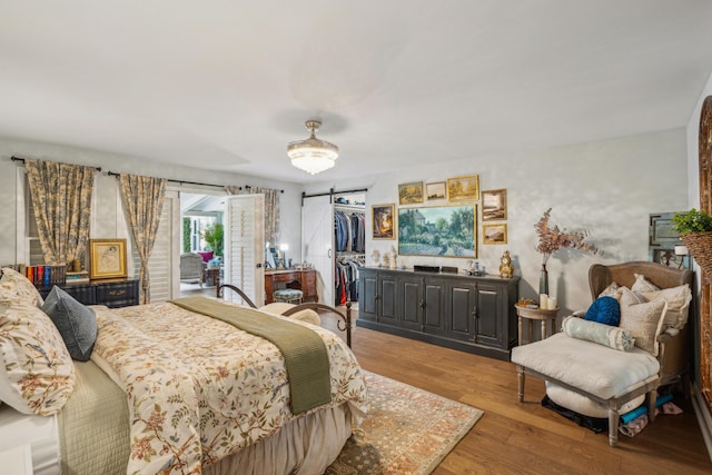 630 Cain Dr, Mount Pleasant, SC 29464 - bedroom with a barn door, light wood-type flooring, a spacious closet, and a closet