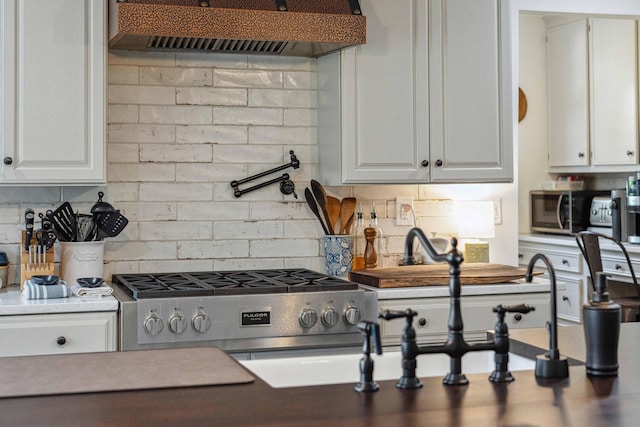 630 Cain Dr, Mount Pleasant, SC 29464 - kitchen with under cabinet range hood, appliances with stainless steel finishes, decorative backsplash, and white cabinetry