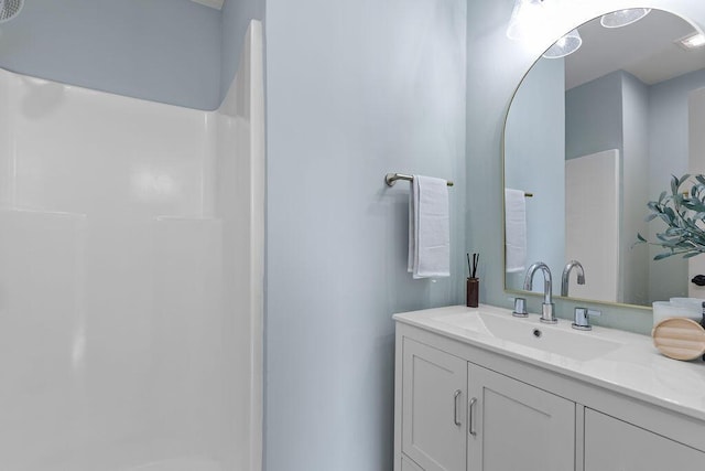 bathroom featuring a shower and vanity