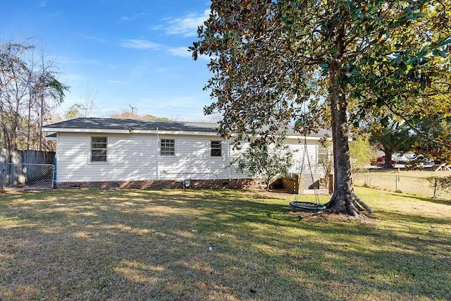 back of house with crawl space, fence, and a lawn