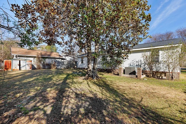 view of yard with an outdoor structure, fence, and a shed