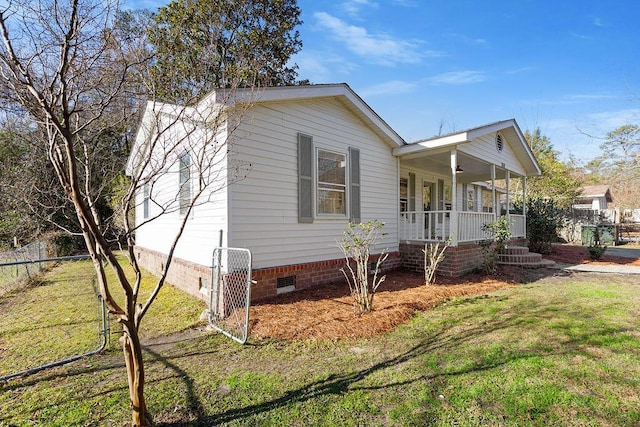 view of front of house featuring crawl space, covered porch, fence, and a front lawn