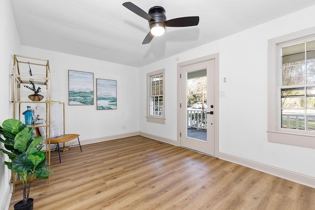 unfurnished room with light wood-style floors, ceiling fan, baseboards, and a wealth of natural light