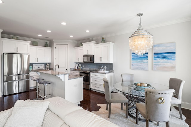 2087 Sterling Marsh Ln, Seabrook Island, SC 29455 - kitchen with appliances with stainless steel finishes, a kitchen breakfast bar, recessed lighting, light stone countertops, and white cabinets