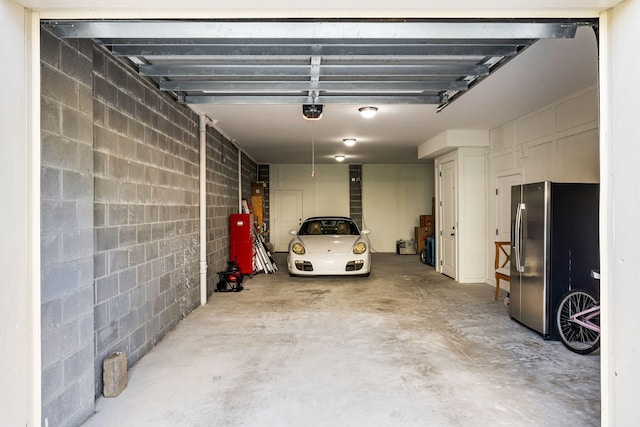 2087 Sterling Marsh Ln, Seabrook Island, SC 29455 - garage featuring stainless steel fridge, a garage door opener, and concrete block wall