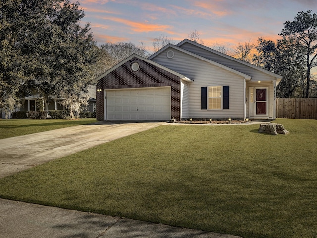 view of front of property with a garage and a yard