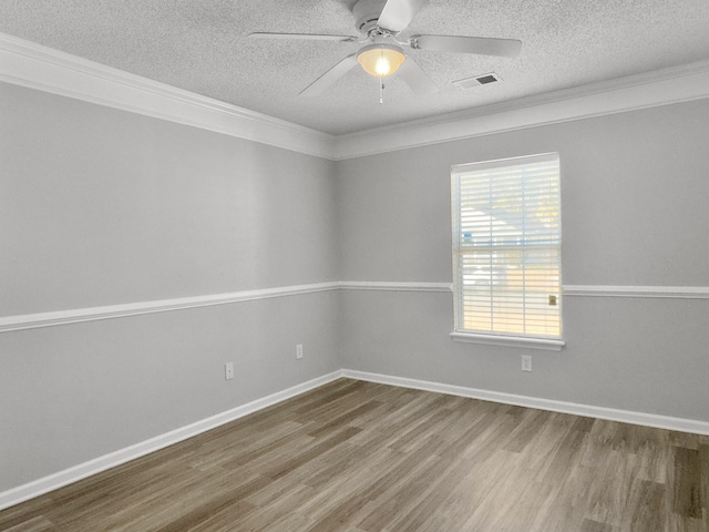 empty room with ceiling fan, a textured ceiling, hardwood / wood-style flooring, and ornamental molding