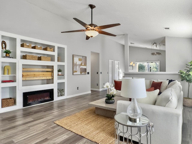 living room featuring ceiling fan, hardwood / wood-style floors, built in features, a textured ceiling, and high vaulted ceiling