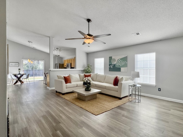 living room with lofted ceiling, plenty of natural light, and hardwood / wood-style flooring