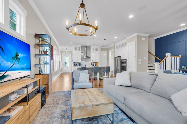 living room featuring an inviting chandelier, wood-type flooring, and ornamental molding