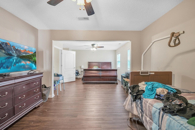 bedroom featuring ceiling fan, dark hardwood / wood-style floors, and a textured ceiling