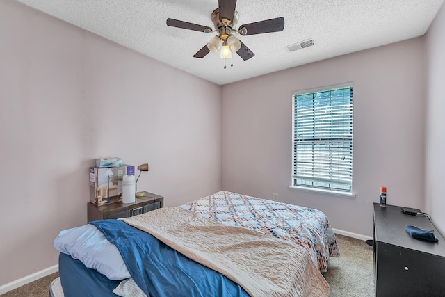 carpeted bedroom with a textured ceiling and ceiling fan